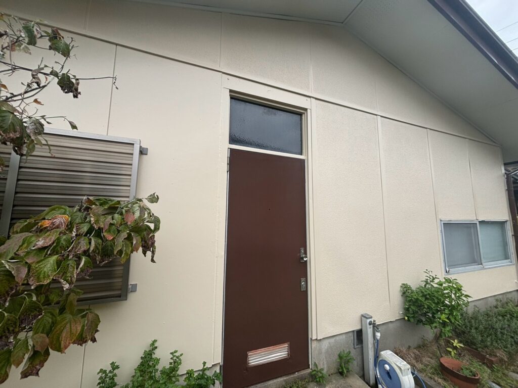 【施工後】<br />
施工前は、外壁全体の塗装が剥がれ、重度のチョーキングや多数のヘアクラックが確認される状態でした。<br />
今回の外壁塗装によって、傷んでいた塗装面を新しい塗膜で覆い、外観と外壁の保護機能の改善を図りました。<br />
さらに、塗装が剥がれていた軒天と、ガラリ角部が陥没していたドアも補修。外壁だけでなく、気になっていた付帯部分も含めて仕上げました。<br />
築25年が経過し、複数の劣化症状が現れていた住宅の外装をまとめて整えた施工事例です。